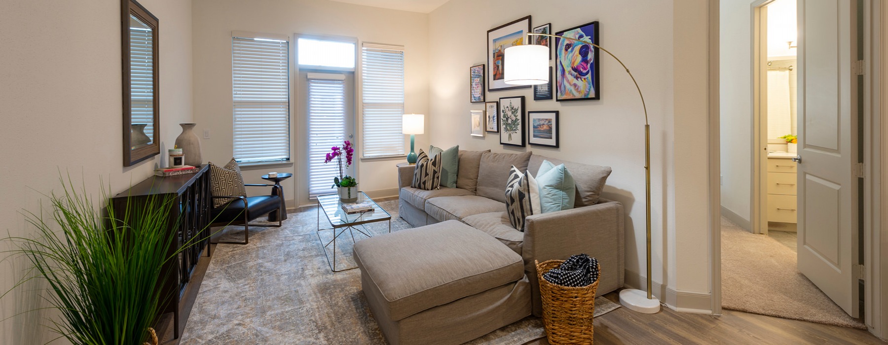living room with windows and glass door covered by blinds