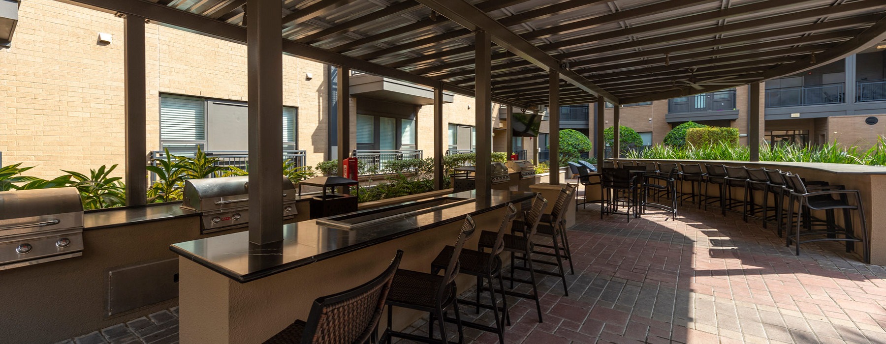 outdoor kitchen pavilion featuring four grill stations, circular bar and big screen TV