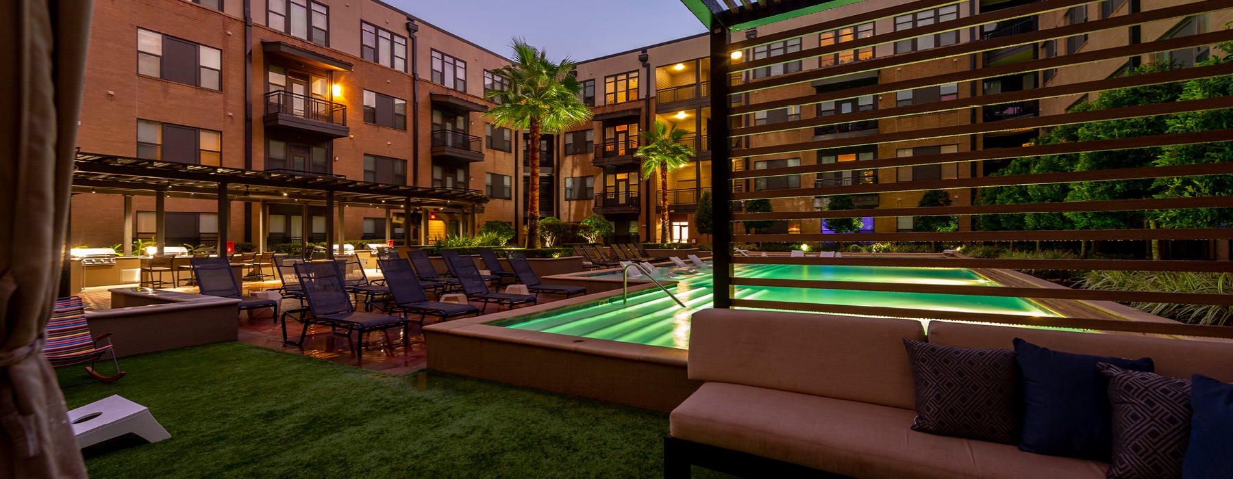 cabanas and game/event lawn lit at night next to pool